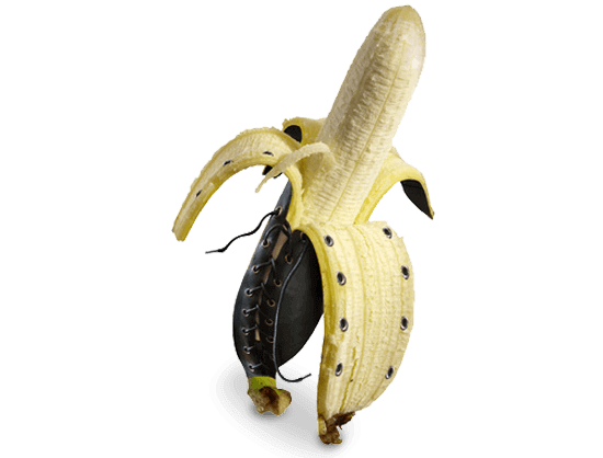 Bildbearbeitung Eine halb geöffnete Banane, bei der durch professionelle Bildbearbeitung die Außenseite der Schale in nietenbesetztes Leder geändert wurde