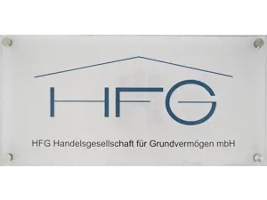 Weißes Acryl-Schild mit Edelstahlbefestigungen, als Motiv blauer Schriftzug "HFG - Handelsgesellschaft für Grundvermögen mbH" und in hellem Grau das Hamburger Wappen im Hintergrund.