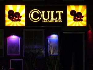 Leuchtkasten der Disco Cult in Hamburg - Mittig das Cult-Logo in gelb, links 80er Club, rechts 90er Club