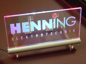 Tischleuchtschild aus Acrylglas, indirekt beleuchtet und mit folienunterlegten Logo