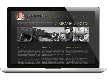 Laptop mit dem Webdesign einer Fotografen-Website - dunkelgrauer Hintergrund mit hellgelber Schrift und Foto im Kopfbereich.