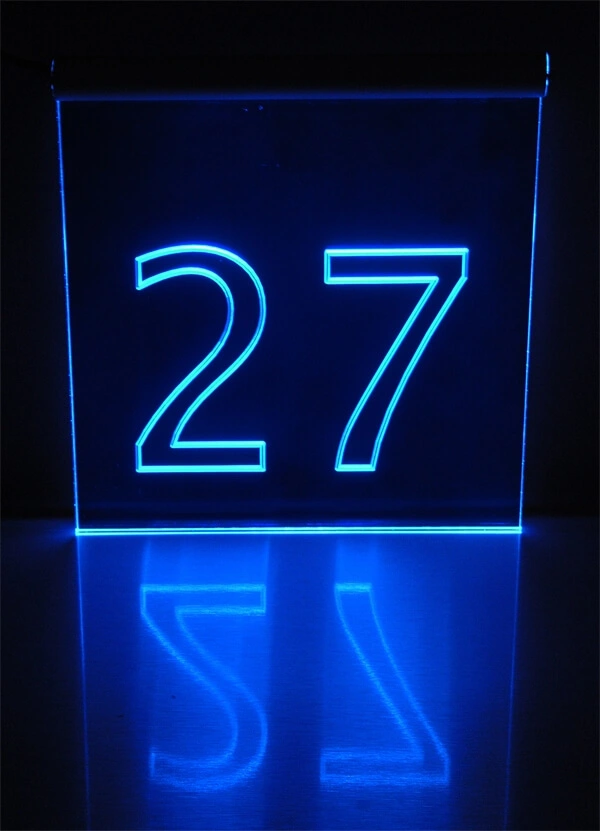 Durchsichtiges Hausnummern-Schild aus Acrylglas mit Hausnummer als Gravur, die durch LED-Kantenstrahler farbig leuchtet.