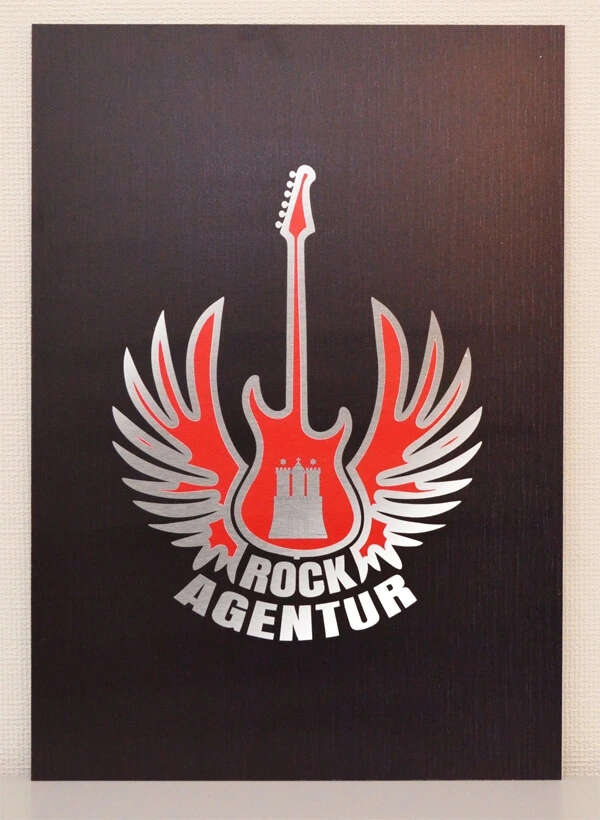 Schwarzes Schild der Rockagentur mit roten Logo und silbernen Outlines.