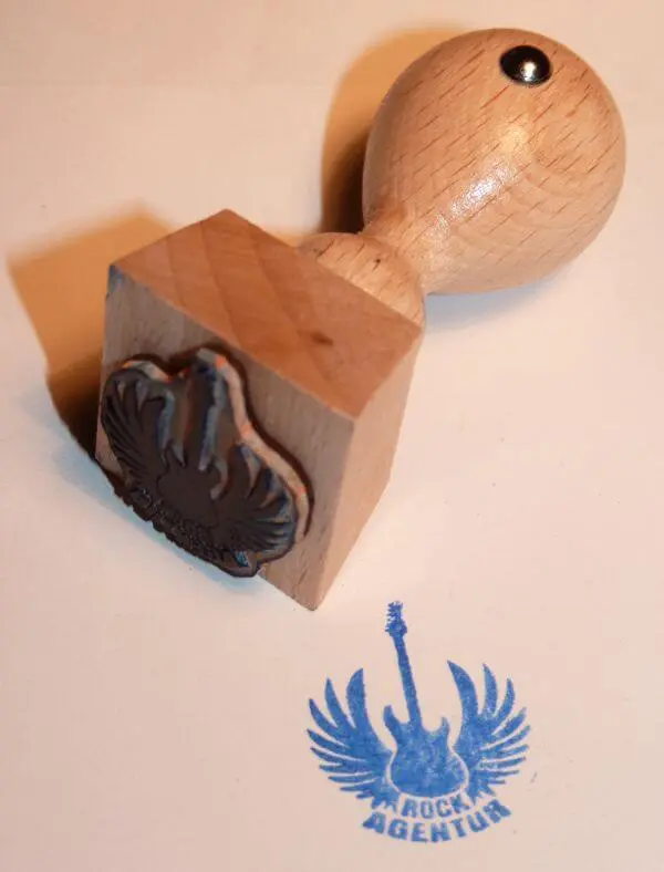 Stempel aus Holz mit Logo der Rockagentur als Stempelmotiv.