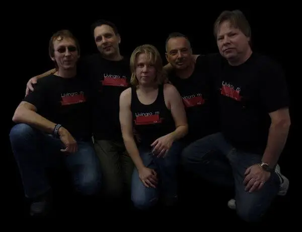 Fünf Musiker, die schwarze T-Shirts und Tank Tops mit dem Logo ihrer Popband auf der Vorderseite tragen.