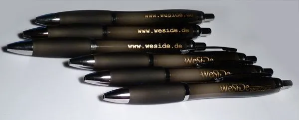 Grau-Braune Kugelschreiber, beschriftet mit goldenem Logo und Internetadresse.